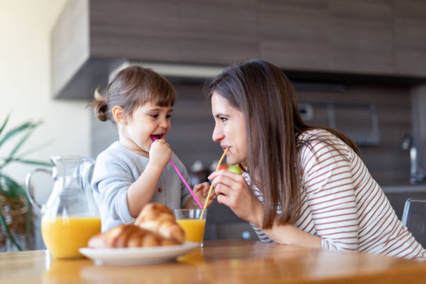 istock Happy mother and daughter drinking juice together 1133893900