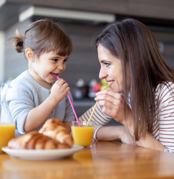 istock Happy mother and daughter drinking juice together 1133894431