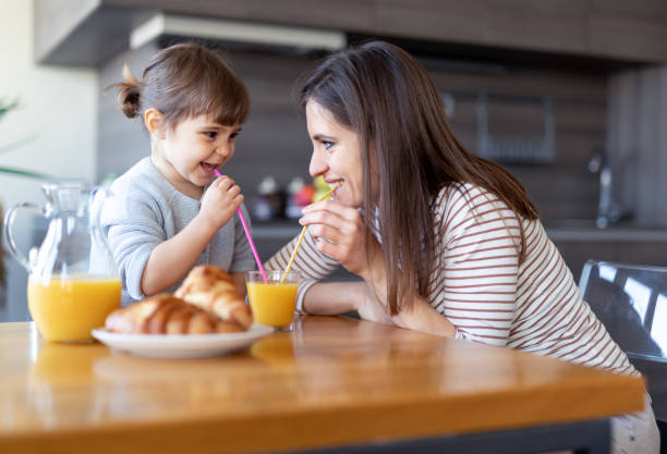 istock Happy mother and daughter drinking juice together 1133894445