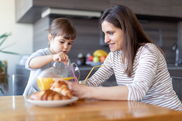 istock Happy mother and daughter drinking juice together 1133894463