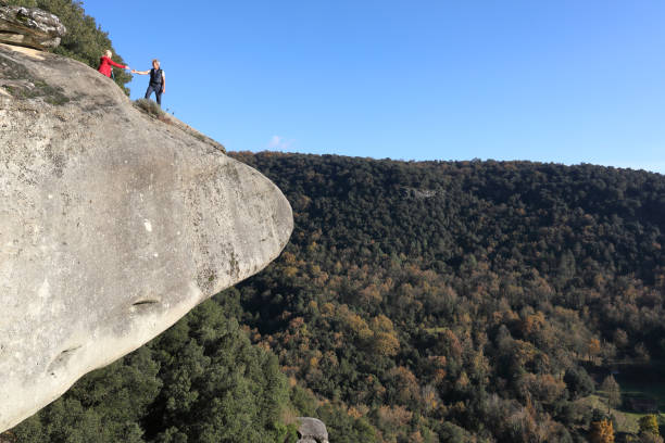 He extending his hand to help her out onto the top