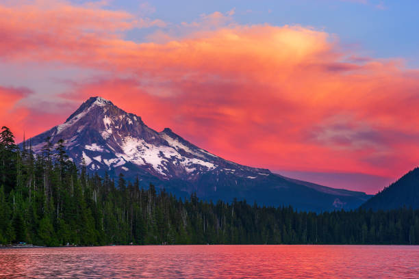 Mt. Hood at sunset from Lost Lake, Oregon. Mt. Hood at sunset with the snowcapped mountain peak and dramatic, orange sky and clouds from the shore of Lost Lake, Oregon. mt hood photos stock pictures, royalty-free photos & images