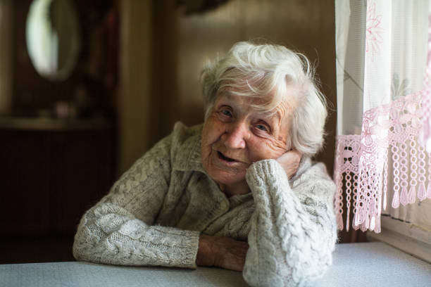 Gray-haired old woman sitting near the window. Gray-haired old woman sitting near the window. grandma portrait stock pictures, royalty-free photos & images