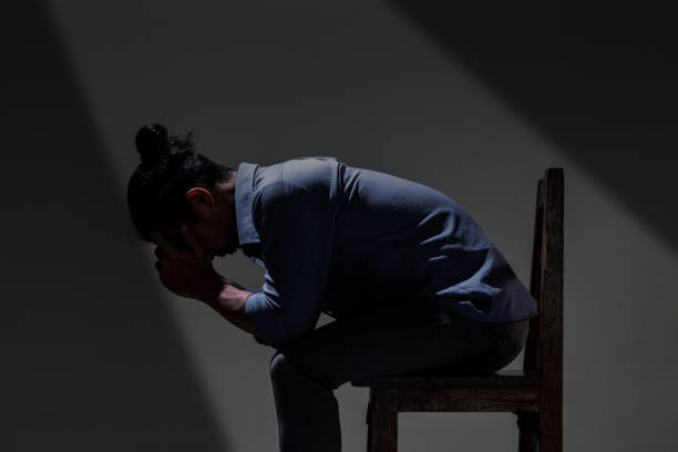 istock An Asian man is suffering from depression in darkness. 1133905257