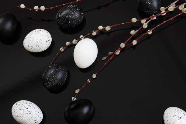 istock Easter. Easter eggs, black and white on a black background. Next to the willow. Selective focus, macro, toning, blur. 1133913695