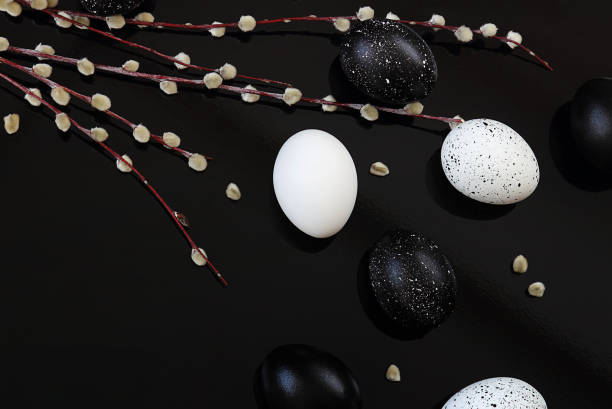 istock Easter. Easter eggs, black and white on a black background. Next to the willow. Selective focus, macro, toning, blur. 1133917539