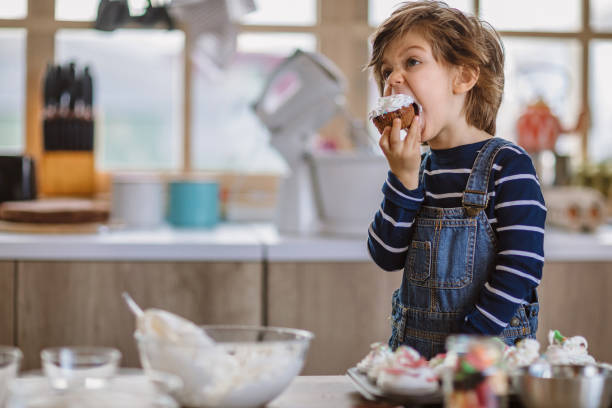 little boy tasting birthday muffins - cupcake chocolate cake dessert imagens e fotografias de stock