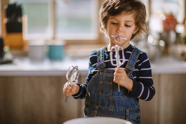 istock Cute Kid Tasting Whipped Cream of Egg Beater 1133919440