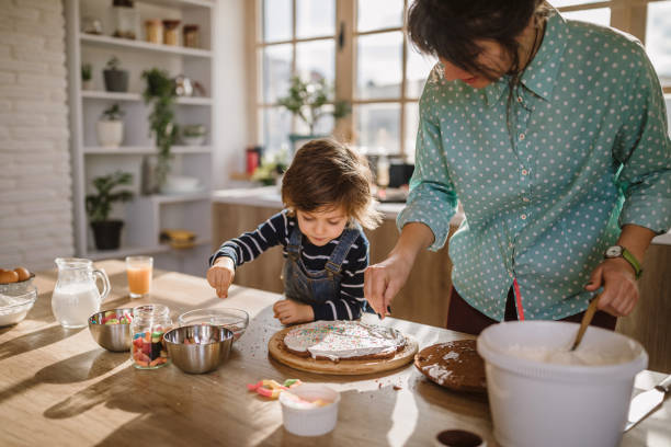 パーティーのためにバースデーケーキを作る - cake birthday domestic kitchen child ストックフォトと画像