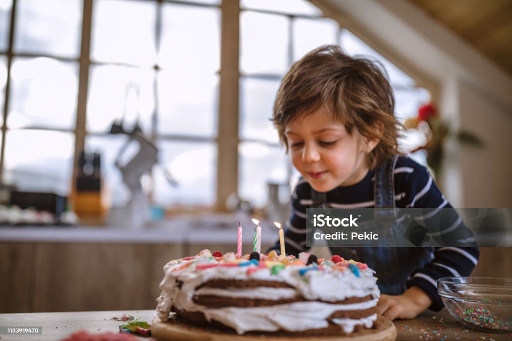 Making a Wish on His Birthday Cute Boy Blowing Birthday Candles at Home Birthday Stock Photo