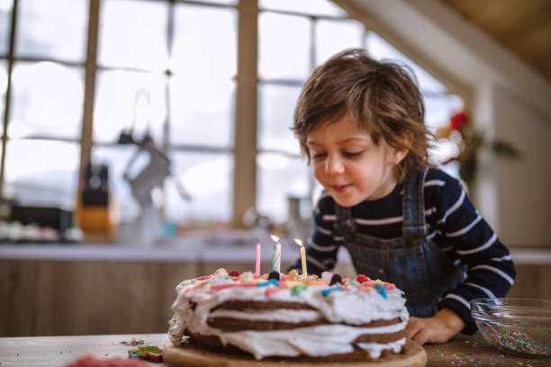 Making a Wish on His Birthday Cute Boy Blowing Birthday Candles at Home i 5 stock pictures, royalty-free photos & images