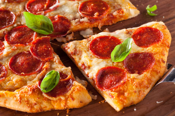 istock Close-up of a pepperoni slice with fresh basil 1133921327