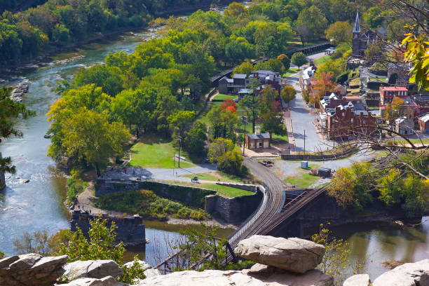 A view on railroad bridge across the river at Harpers Ferry National Historic Park and town. Early autumn signs in West Virginia park landscape. harpers ferry photos stock pictures, royalty-free photos & images
