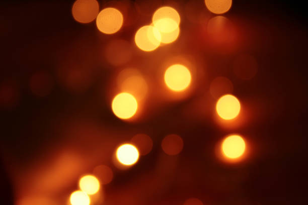 istock shades of light gold and red abstract blurred glowing light particles 1133930627