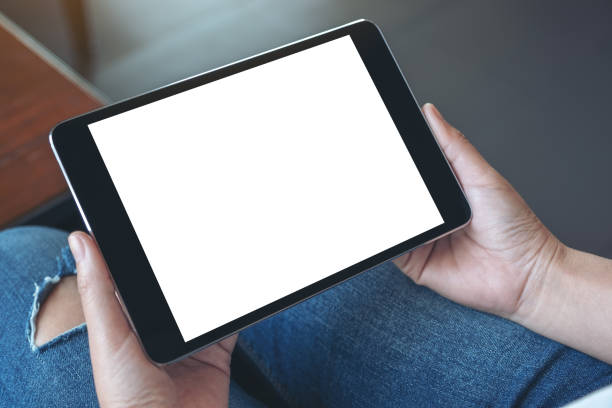 istock a woman sitting and holding black tablet pc with blank white desktop screen 1133931967