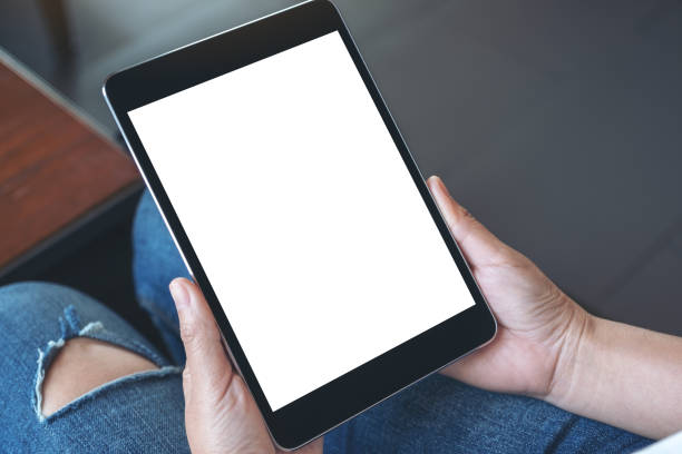 istock a woman sitting and holding black tablet pc with blank white desktop screen 1133931968