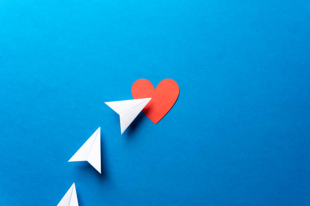 istock Three paper airplanes with red heart shape on blue background. Sharing and send concept. with red heart shape on blue background. Sharing and send symbol concept. Airplane flight transport sign. Landing page concept. Paper plane email web message sending. 1133931976
