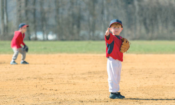 Young Baseball Player Giving a Thumbs Up A young boy giving his parents a "thumbs up" reassuring them that he is ok. baseball uniform photos stock pictures, royalty-free photos & images