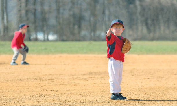 Young Baseball Player Giving a Thumbs Up A young boy giving his parents a "thumbs up" reassuring them that he is ok. baseball hand signals stock pictures, royalty-free photos & images