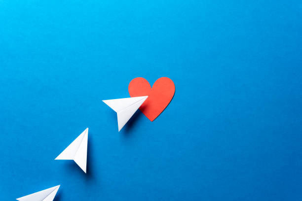 istock Paper airplanes with red heart shape on blue background. Sharing and send concept. with red heart shape on blue background. Sharing and send symbol concept. Airplane flight transport sign. Landing page concept. Paper plane email web message sending. 1133935728