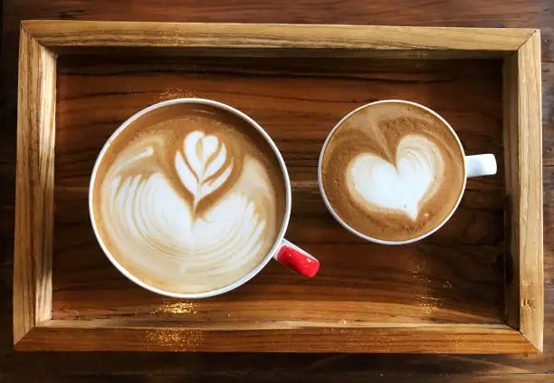 Flat white latte Vs Piccolo latte in white cup on the wooden table, Romantic concept.