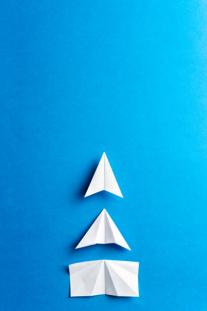 Progress concept. Development attainment, motivation, growth concept. Business concept of goals, success, achievement and challenge. White paper airplanes under construction on blue background. stock photo