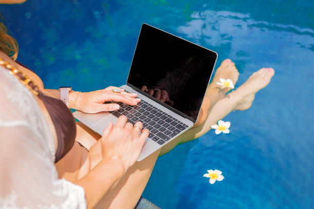 istock Woman sitting by the pool and using laptop. 1133937661