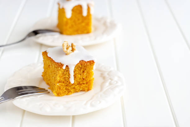 istock Homemade nuts carrot cake with icing cream white plate. Selective focus. Close up. Selective focus. 1133944224