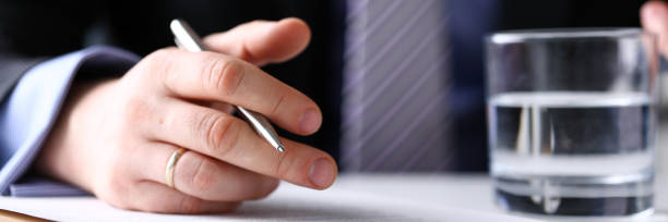 istock Arm fill and sign important form clipped to pad with silver pen 1133953636