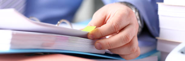 Clerk arm bend over pages in pile of bookmarked documents Clerk arm bend over pages in pile of bookmarked documents closeup. Open catalogue correspondence order organization heap archive job sorting records concept letterbox view corner tip stock pictures, royalty-free photos & images