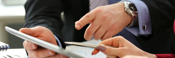 istock Businessmen and woman look and study statistics on electronic pad 1133953697