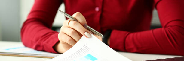 istock Female arm holding silver pen point in financial graph 1133953704
