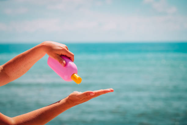 sun protection- woman hand spread cream on beach
