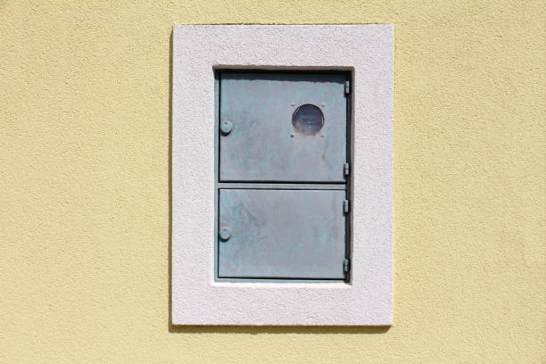 istock Outdoor locked metal electrical meter box with switch box mounted on house wall with new facade surrounded with white frame 1133956982