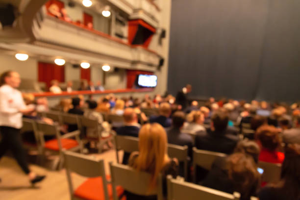 People in the theater auditorium before the performance. Blurred defocused image.