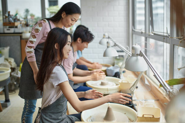 istock Mature teacher guiding students at pottery store 1133964476