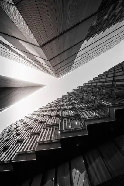 Highly detailed abstract wide angle view up towards the sky in the financial district of London City and its ultra modern contemporary buildings. Shot on Canon EOS R system, 14mm wide angle prime lens. Monochrome (black and white) edit with high contrast ideal for background.