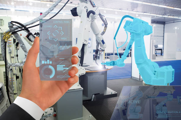 istock Engineer uses a futuristic transparent smartphone to control robots in a smart factory 1133970148