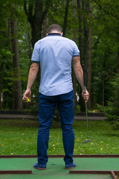 istock green mini Golf course, men in blue pants, rear view 1133974214