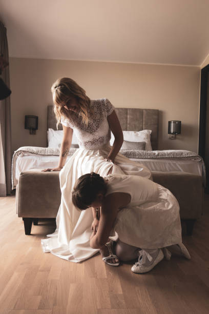 istock Bridesmaid Helping the Bride to Put on Wedding Shoes 1133974679