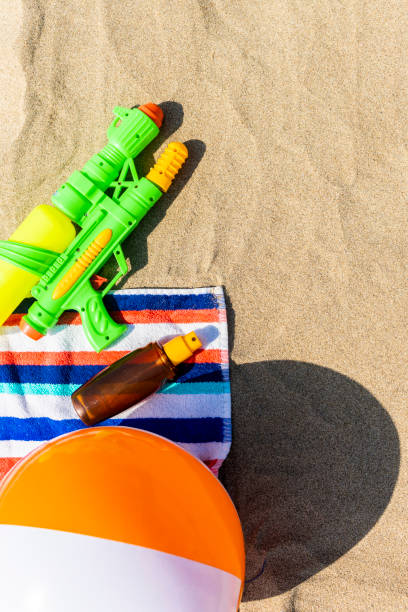 istock Towel, beach ball, sunscreen and water gun on the beach 1133974880