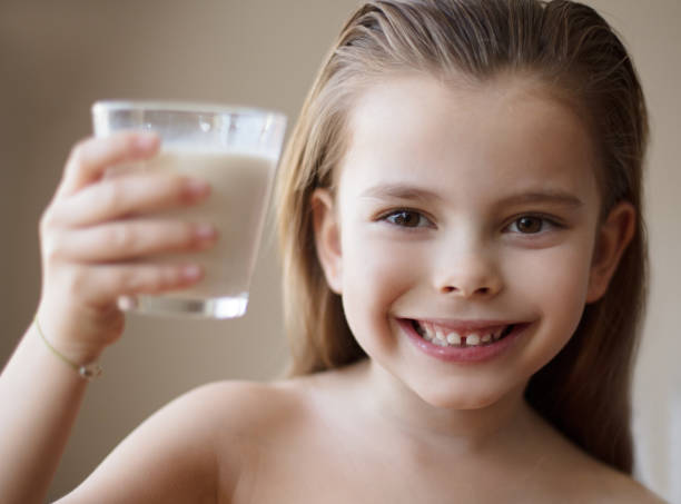 For strong bones. For strong bones. Little girl drinking milk. Close up. thumbs up for skiing stock pictures, royalty-free photos & images