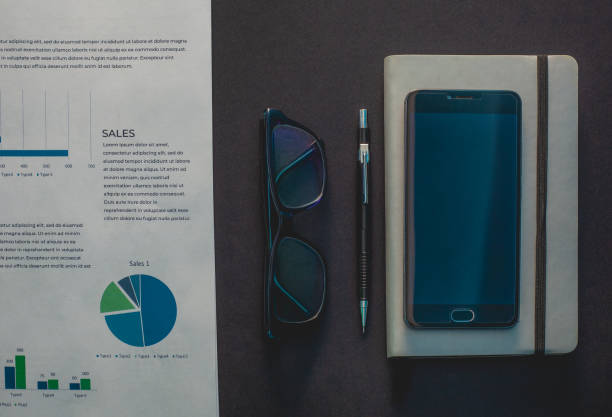 istock Glasses and phone lie on a black background next to a gray notepad and a sheet with a schedule 1133978238