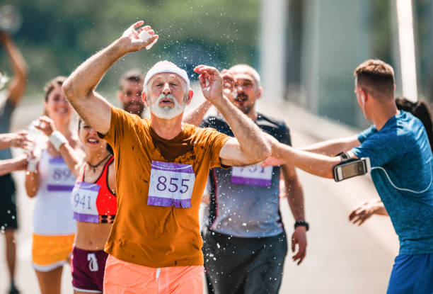 istock Senior marathon runner refreshing himself with water during a race. 1133978618