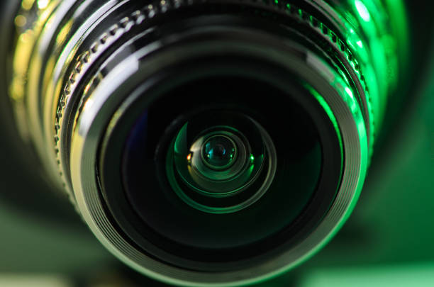 istock The camera lens is illuminated in yellow-green. Horizontal photo. 1133983320