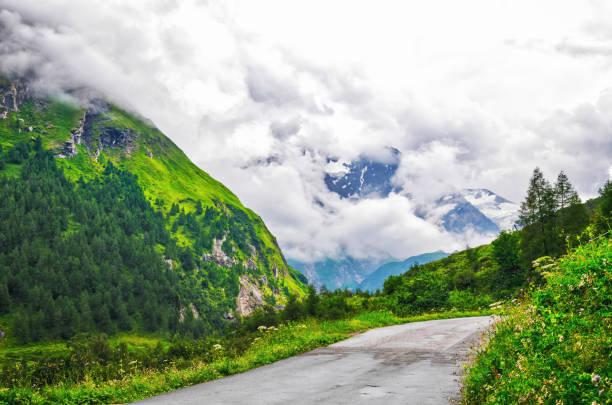 French Alpine mountain panoramic view with jagged peaks, glaciers and dramatic clouds in summertime