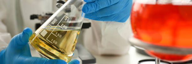 regard de chimiste mâle au microscope maintiennent le tube d'essai - textile scientific experiment laboratory textile industry photos et images de collection