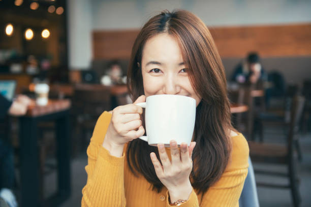 istock beautiful young woman drinking coffee 1133987534