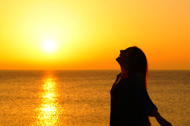 istock Happy woman on the beach breathing at sunset 1133987788