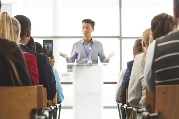 istock Businessman taking photo with mobile phone during seminar 1133991153